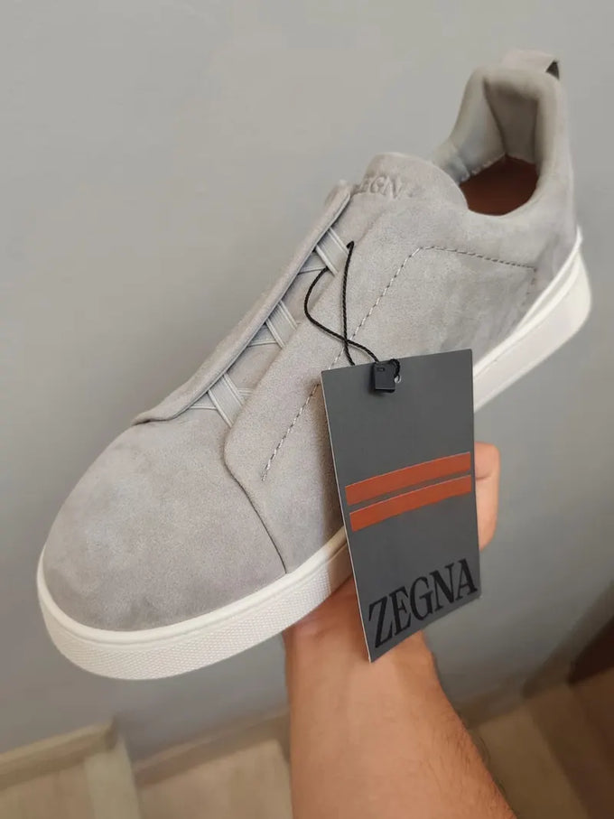 Foto do cliente: tênis Zegna de camurça cinza na mão, com a etiqueta